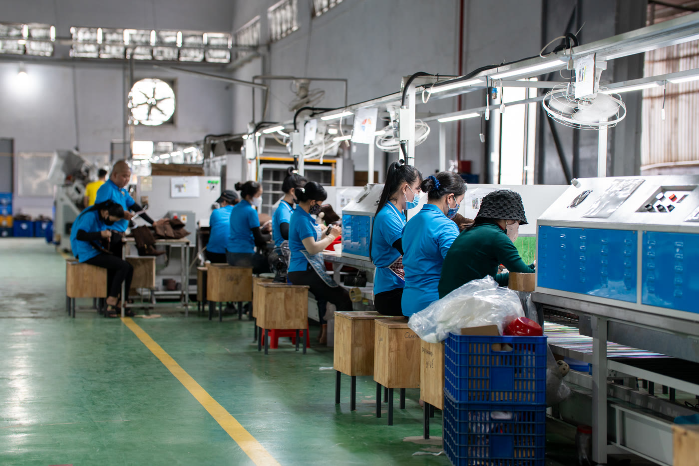 A long aisle running between two assembly lines, benches on both sides.