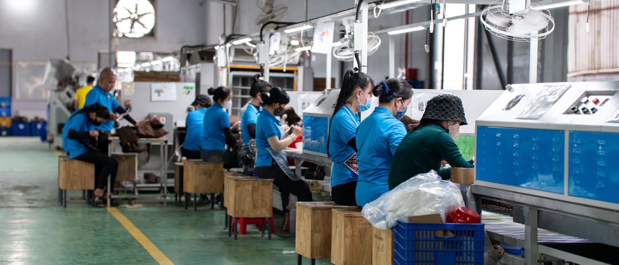 A wide view down the assembly floor at Binh Duong, with workers at benches along both sides of the line.