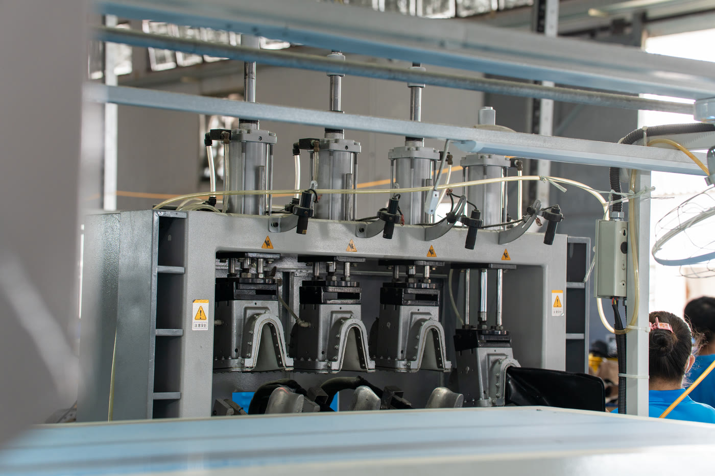 A bank of four pneumatic presses fitted with shoe-shaped moulds.