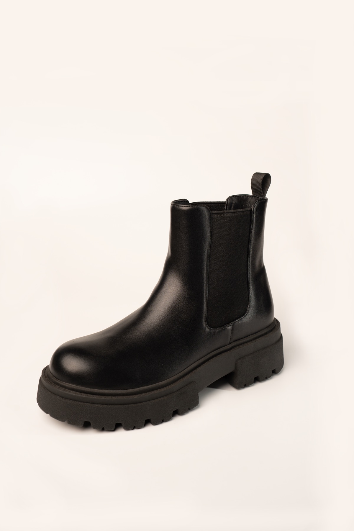 Studio shot of a black Chelsea ankle boot with elastic gussets and an exaggerated lug sole.