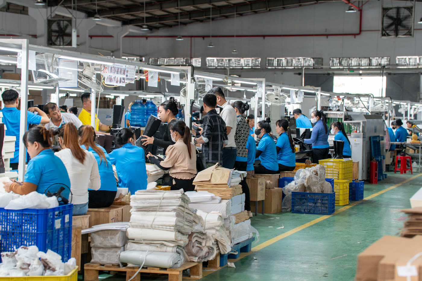 Workers boxing finished pairs for export at the packing benches.