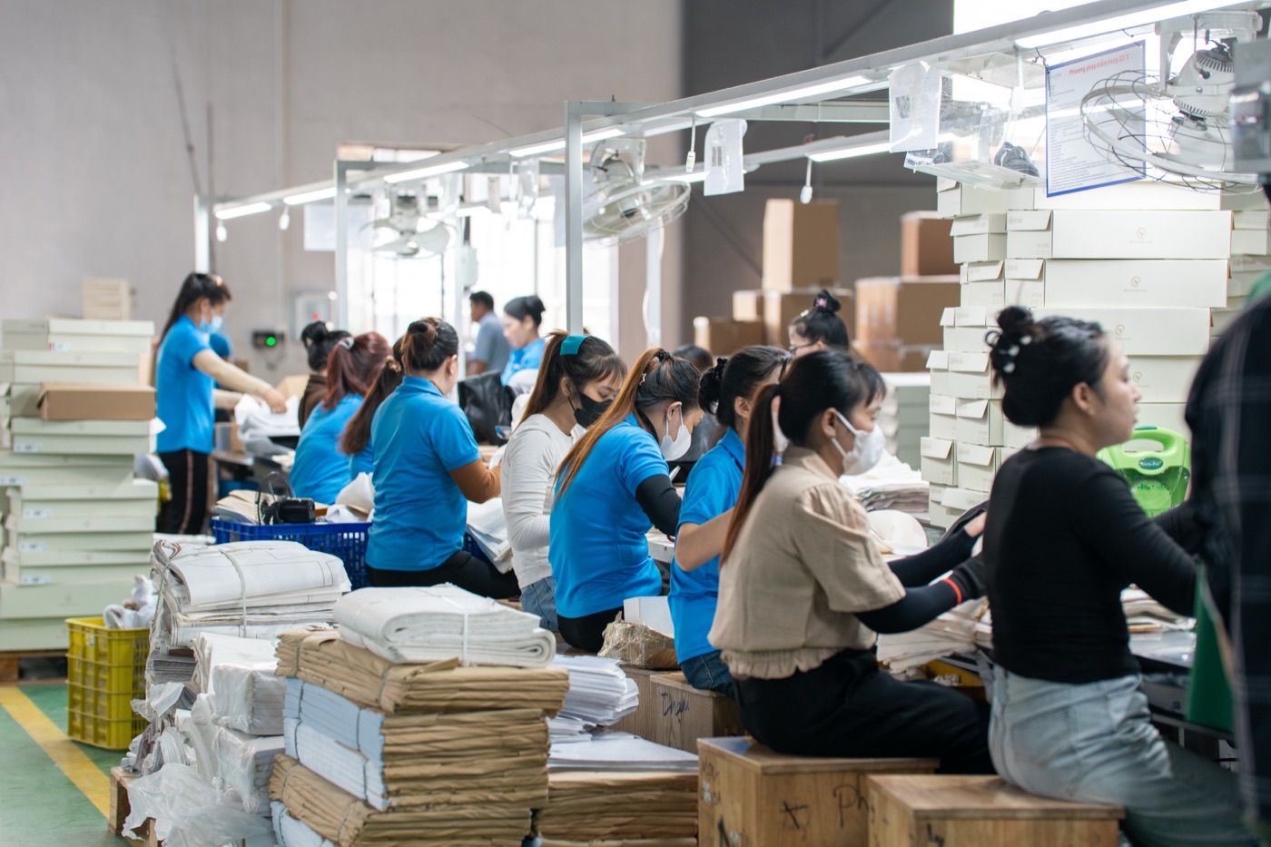 The packing benches, with shoeboxes and export cartons stacked beside the workers.